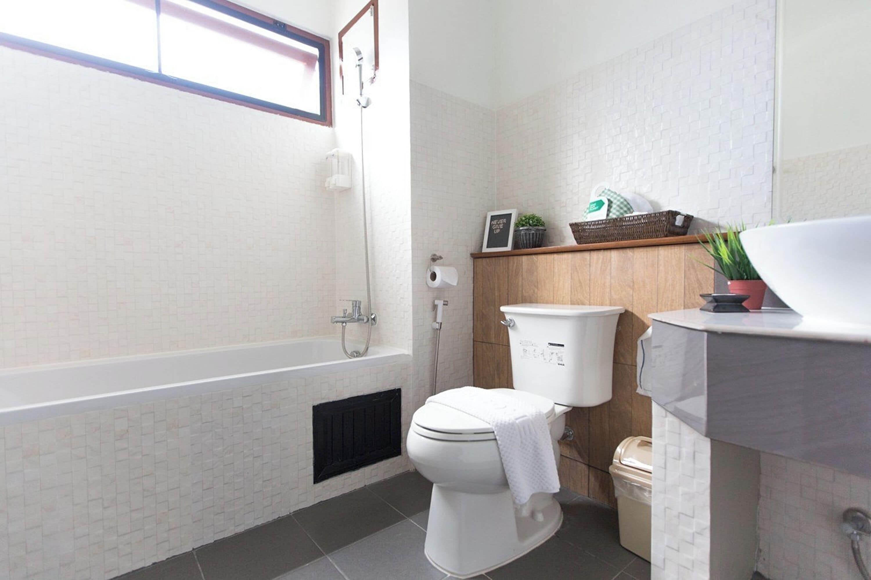 Une salle de bain moderne avec des toilettes blanches, une baignoire, une douche et un lavabo.