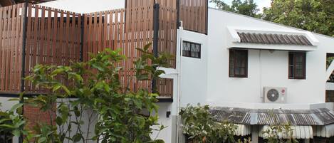 A modern building with a wooden facade, a white exterior, and a tiled roof.