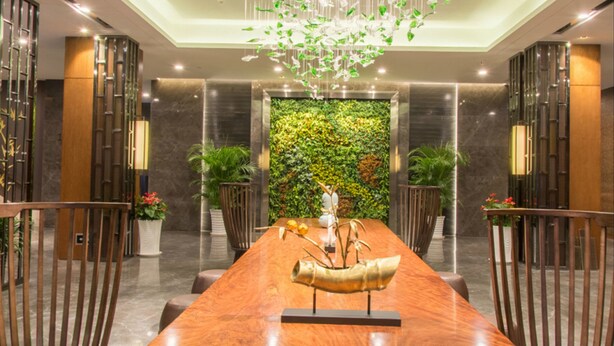 A spacious dining area with a long wooden table, modern chairs, and a decorative hanging light fixture. - Chengdu E Hotel (Chengdu)
