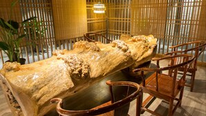 A wooden dining table with chairs, surrounded by bamboo partitions. - Chengdu E Hotel (Chengdu)