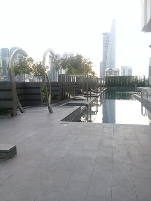 A rooftop pool area with modern architectural features, including a reflective pool and abstract metal structures. - Kardean Intl at Vogue Suite (Kuala Lumpur)