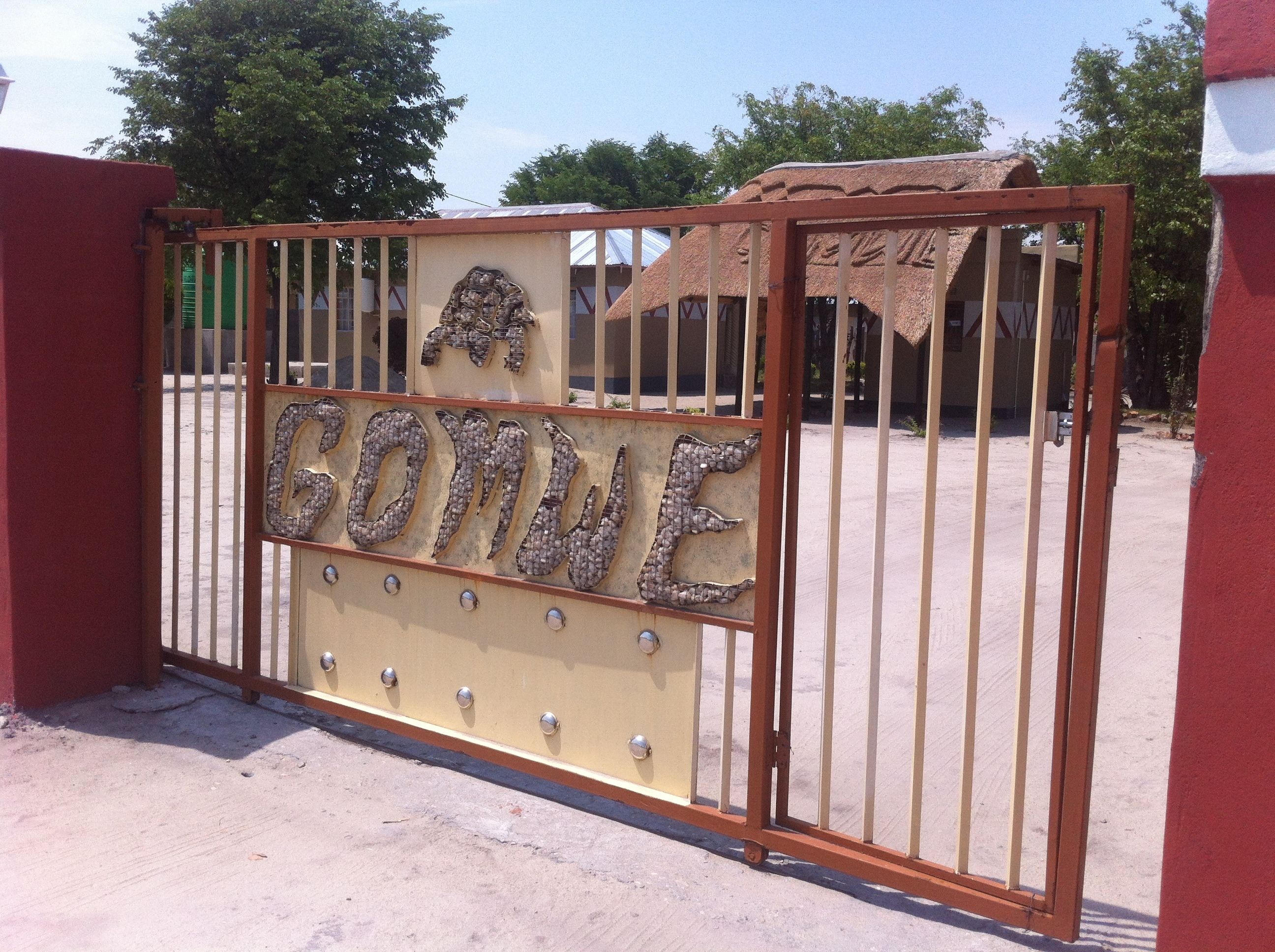 A metal gate with the word "GOMME" spelled out in mosaic tiles.