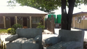 Two stone benches in a courtyard with a building in the background.