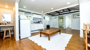 Une cuisine moderne avec des meubles blancs, une table en bois et un tapis blanc.