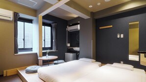 A hotel room with a large bed, a small round table, a sink, and a mirror. - LINNAS Kanazawa (Kanazawa)