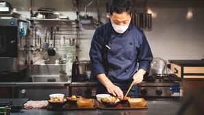 A chef preparing food in a professional kitchen with stainless steel appliances and a clean, organized layout. - LINNAS Kanazawa (Kanazawa)