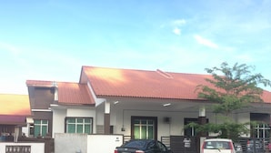 Un edificio residenziale con tetto in tegole rosse, numerose finestre e un ingresso con cancello.