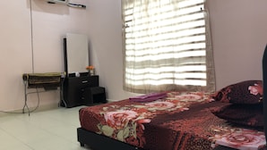 Una camera da letto con un letto, una cassettiera, uno specchio e un condizionatore.