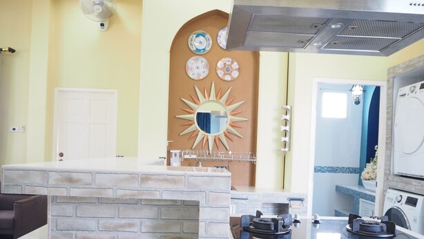 A kitchen with a brick backsplash, a stove, and a sink. - Baan Tukta (Cha-am)