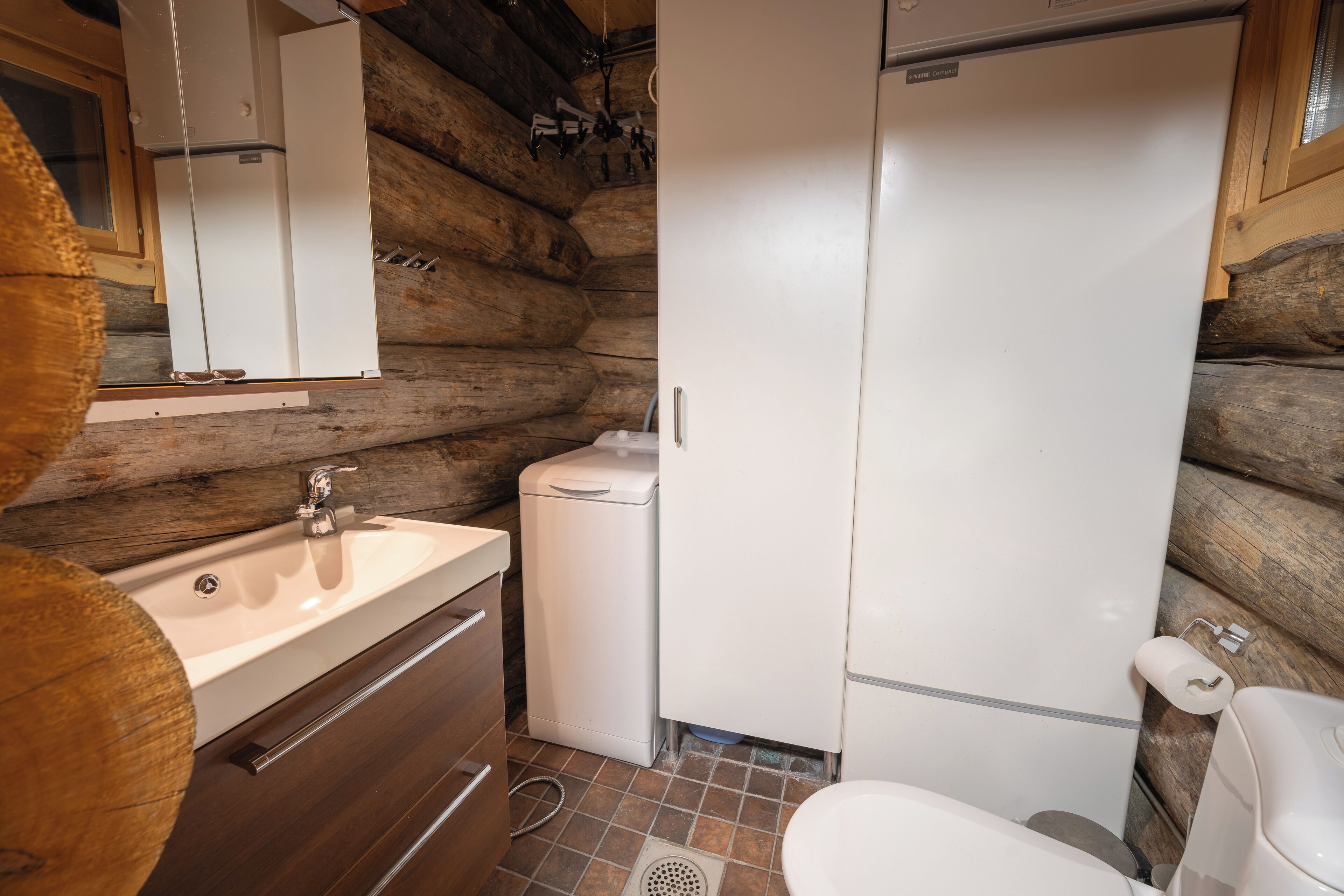A compact bathroom with a sink, toilet, and a small white cabinet.
