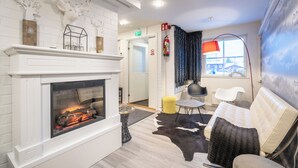 Un salon moderne avec une cheminée, un canapé, une table basse et un tapis.