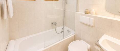 Un baño con bañera, inodoro y cabina de ducha.