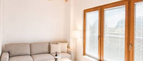 A living room with a sofa, a coffee table, a lamp, and a radiator.