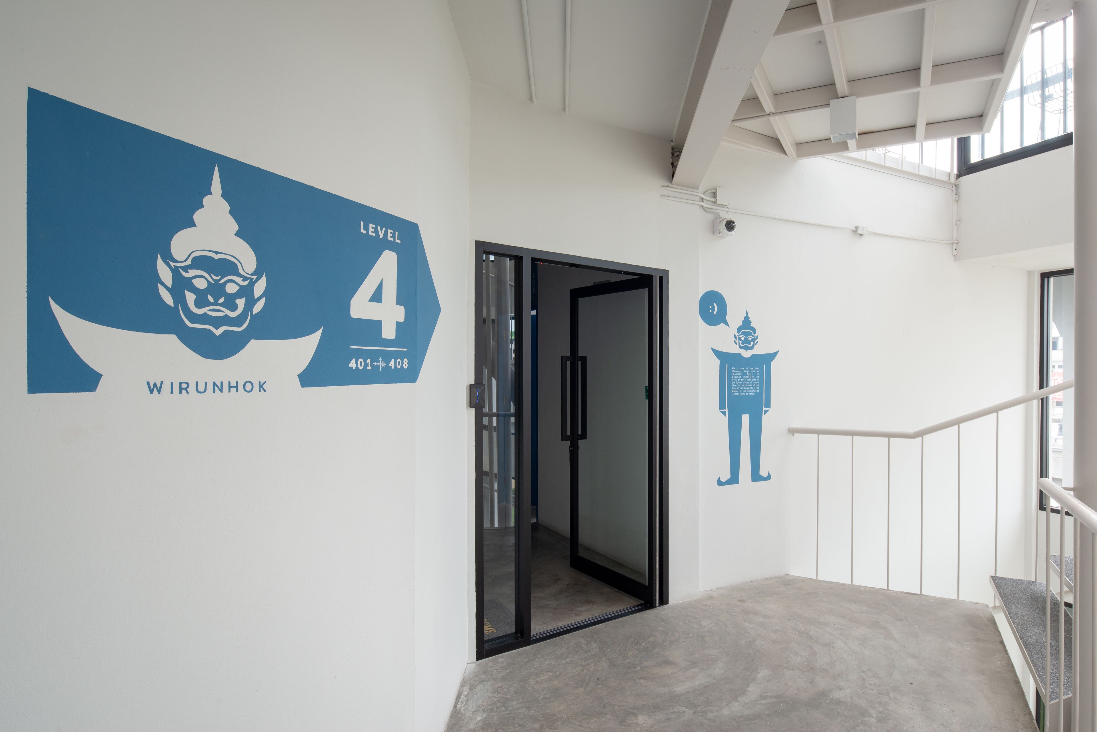 A stairwell with a sign indicating Level 4, a glass door, and a wall with a blue graphic and text.