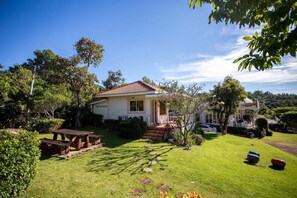 A house with a well-maintained lawn, a picnic table, and a small garden.