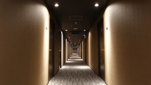 A long, narrow hallway with a patterned carpet and recessed lighting. - Act Hotel Roppongi (Tokyo)