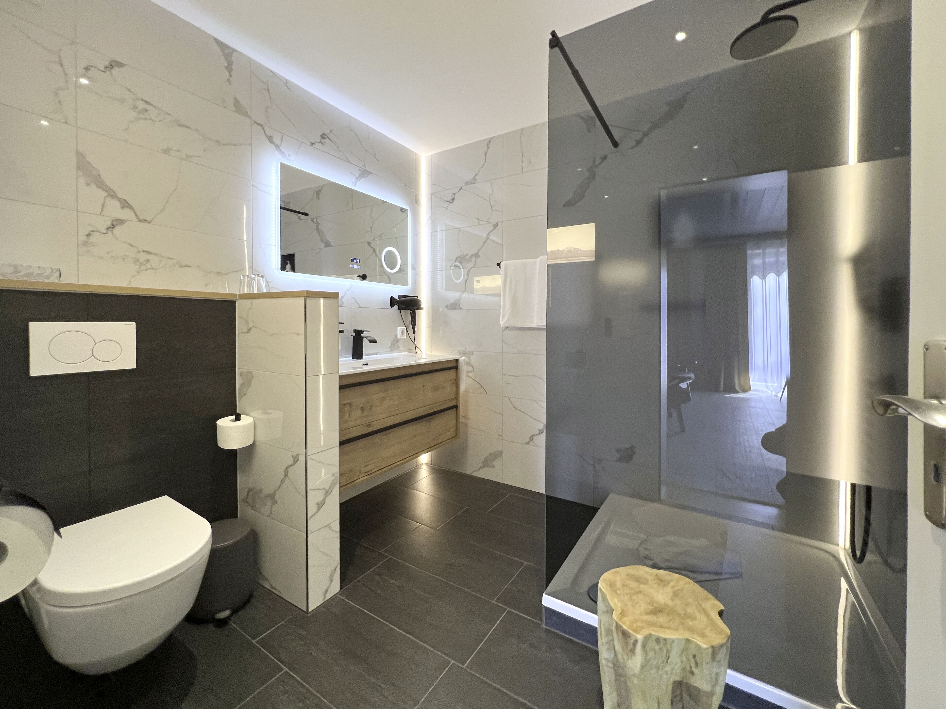A modern bathroom with a toilet, sink, and shower area.