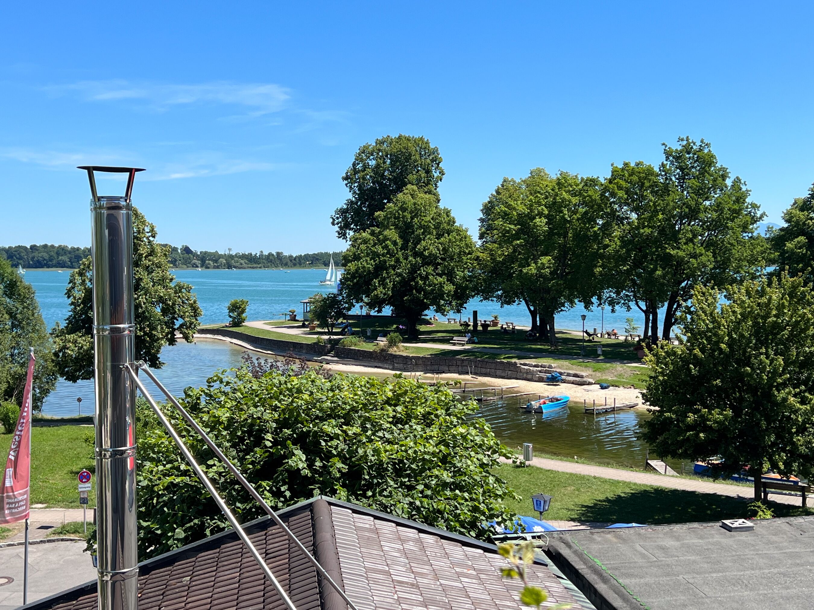 Un parco sul lago con un gazebo, tavoli da picnic e un molo per barche.