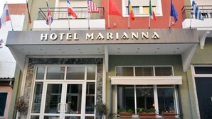 Exterior del Hotel Marianna, con un cartel, varias banderas y una decoración con estrellas en la ventana.