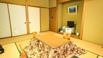 A traditional Japanese room with tatami flooring, a low table, and sliding doors.