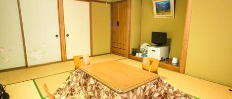 A traditional Japanese room with tatami flooring, a low table, and sliding doors.