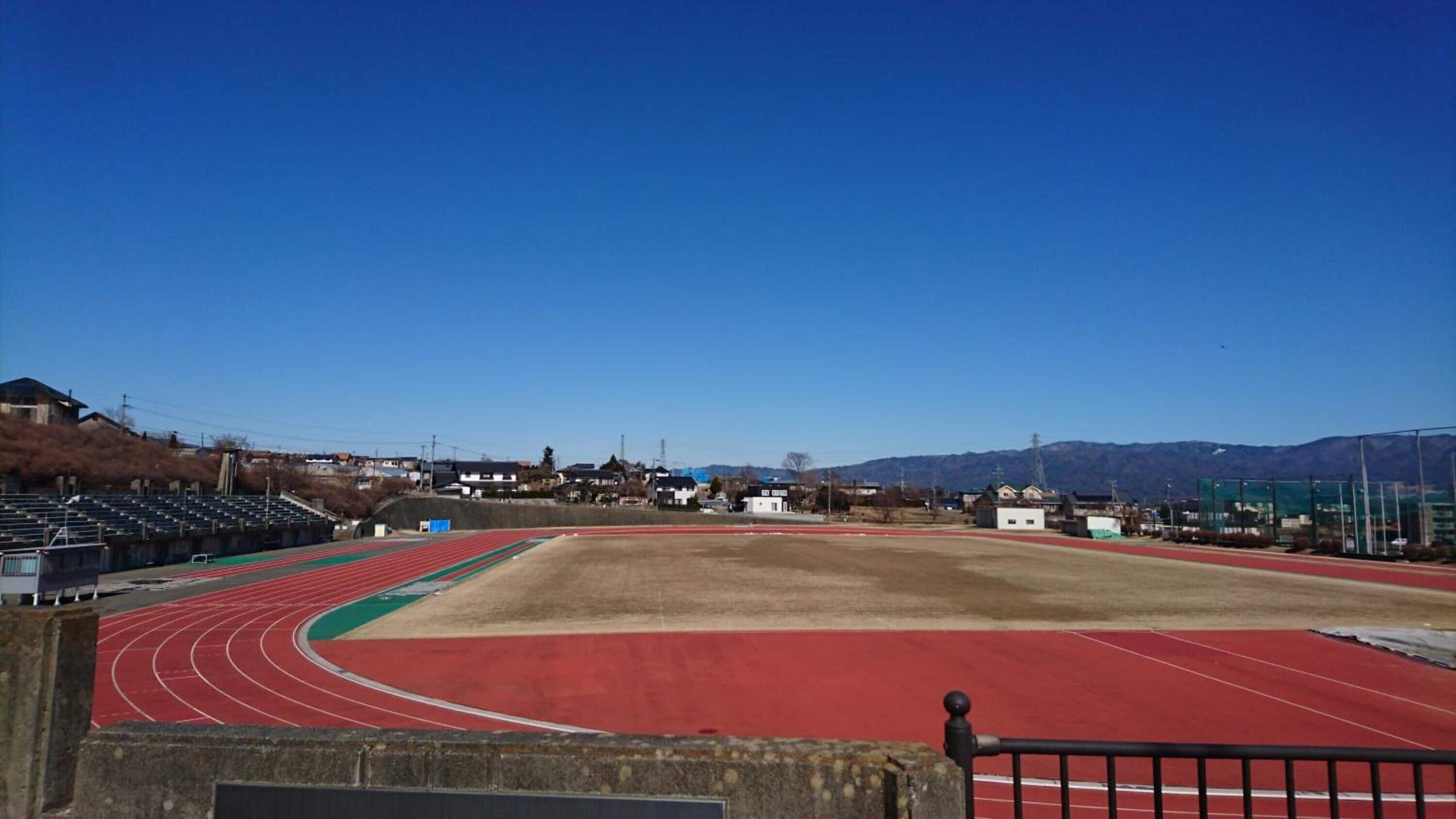 Et stort, tomt stadion med løbebane og tilskuerpladser.
