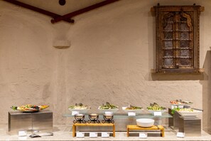 Un buffet proposant une variété de plats et d’ustensiles.
