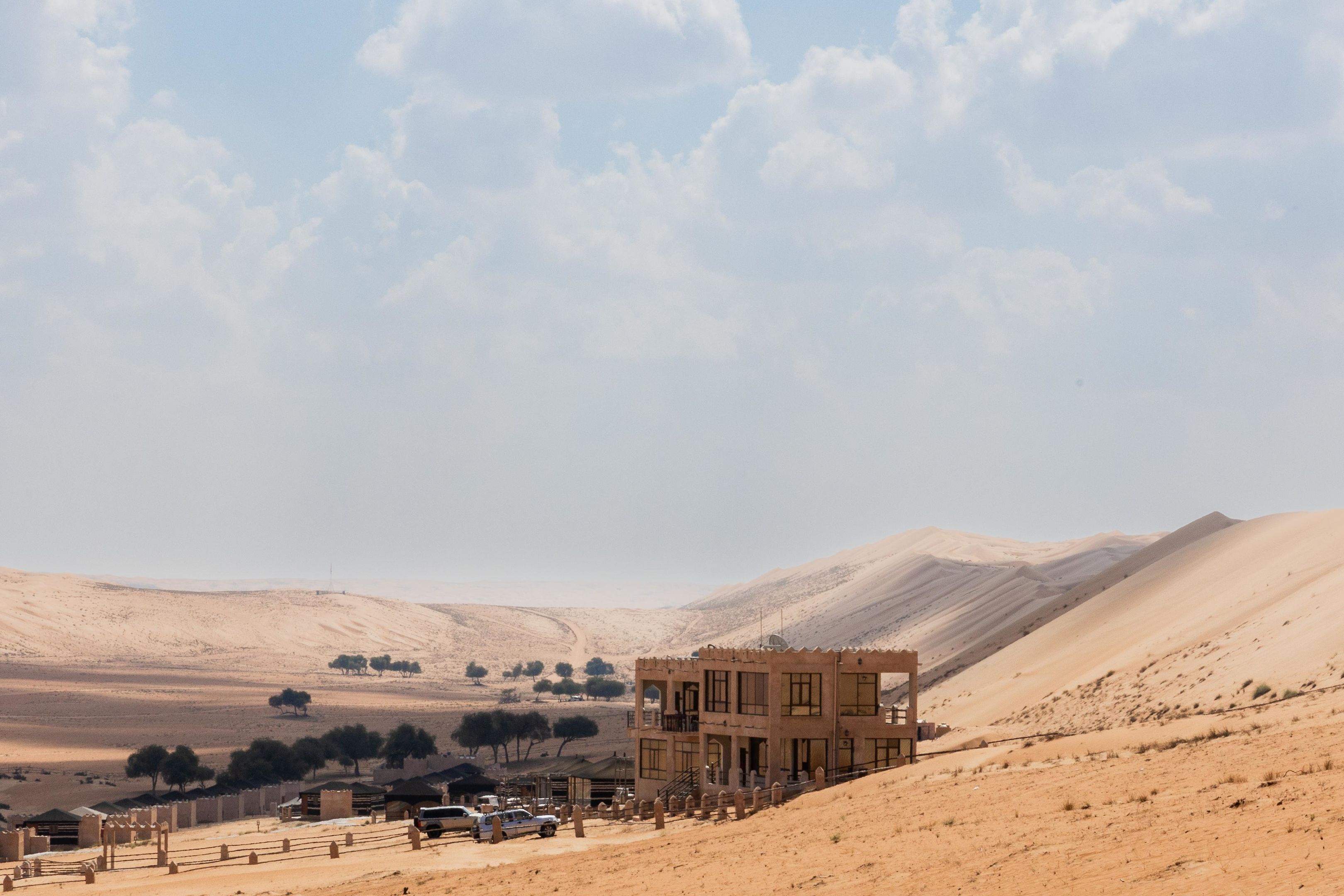 A desert landscape with a building featuring multiple levels and balconies.