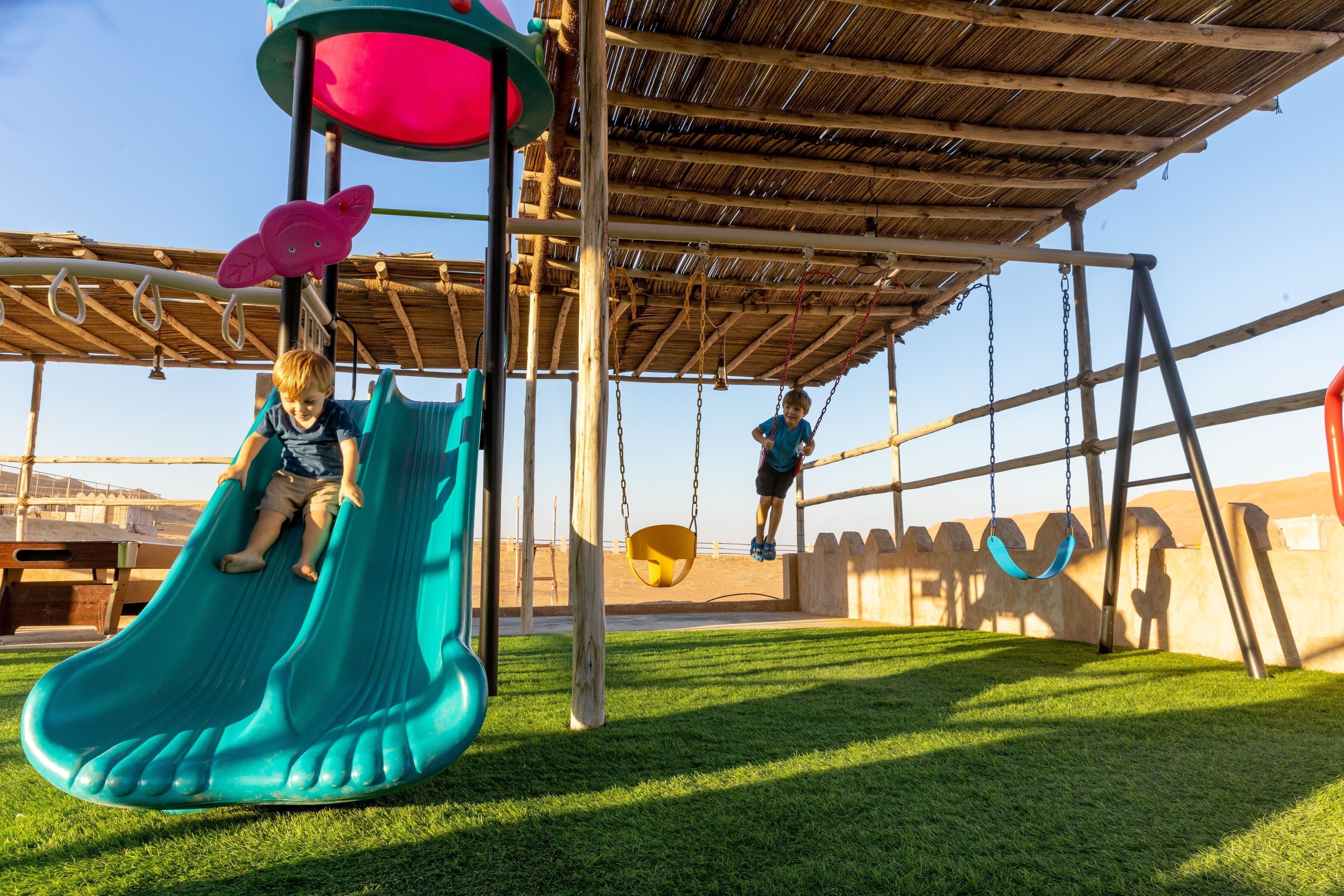 A playground with a slide and swings.