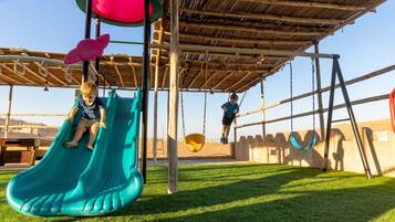 A playground with a slide and swings.