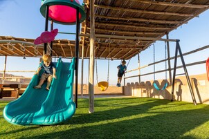 A playground with a slide and swings.