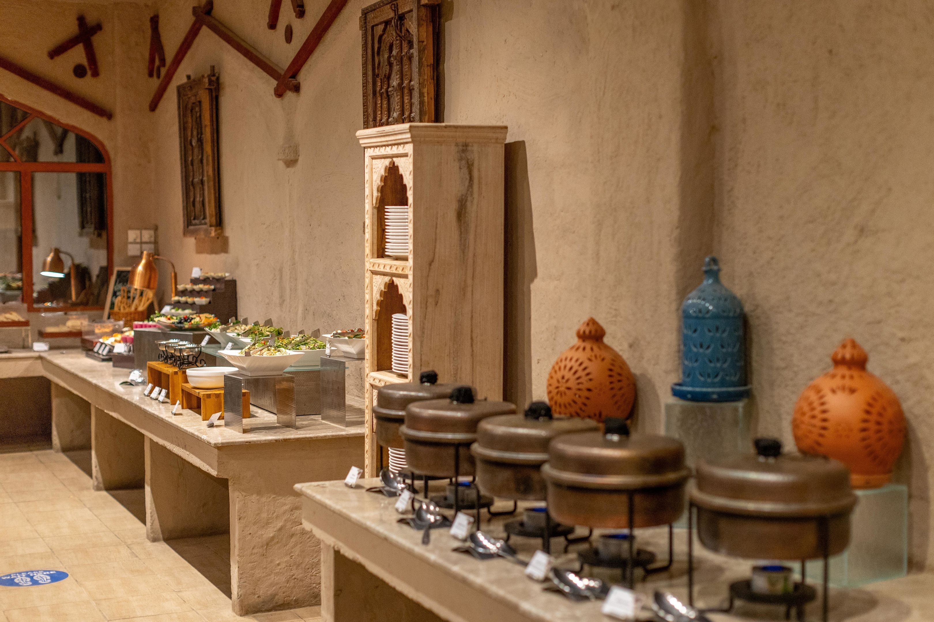 A buffet setup with various food items and serving utensils.