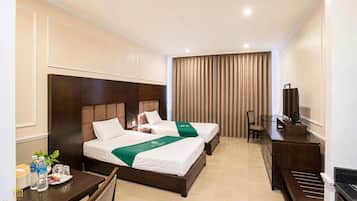 A hotel room with two beds, a desk, a chair, a television, and a curtain.
