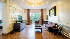 Amplia sala de estar con piso de madera, un sofá, una mesa de centro y un televisor sobre un mueble.