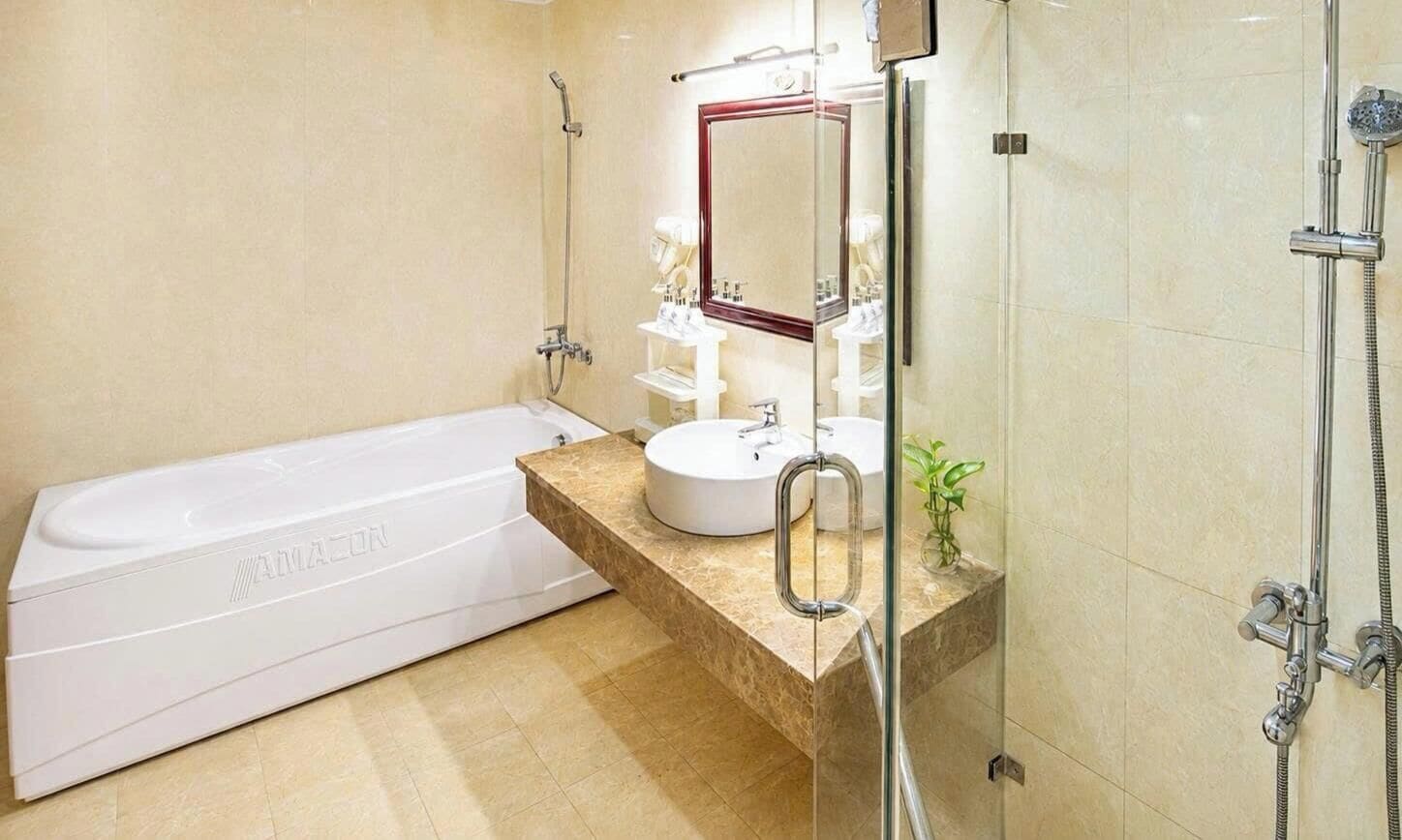 A modern bathroom with a white bathtub, a sink with a mirror, and a shower area.