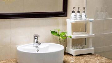 Une salle de bain avec un lavabo rond blanc, un miroir et une étagère contenant des articles de toilette.