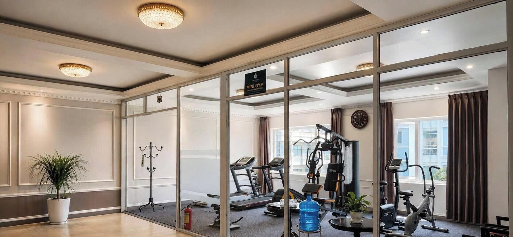 A hotel room with a gym area, including exercise equipment and a water bottle.
