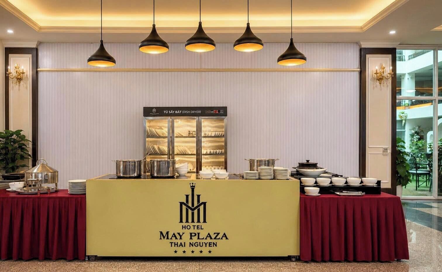 A buffet setup in a hotel with a yellow counter, buffet items, and overhead lighting.