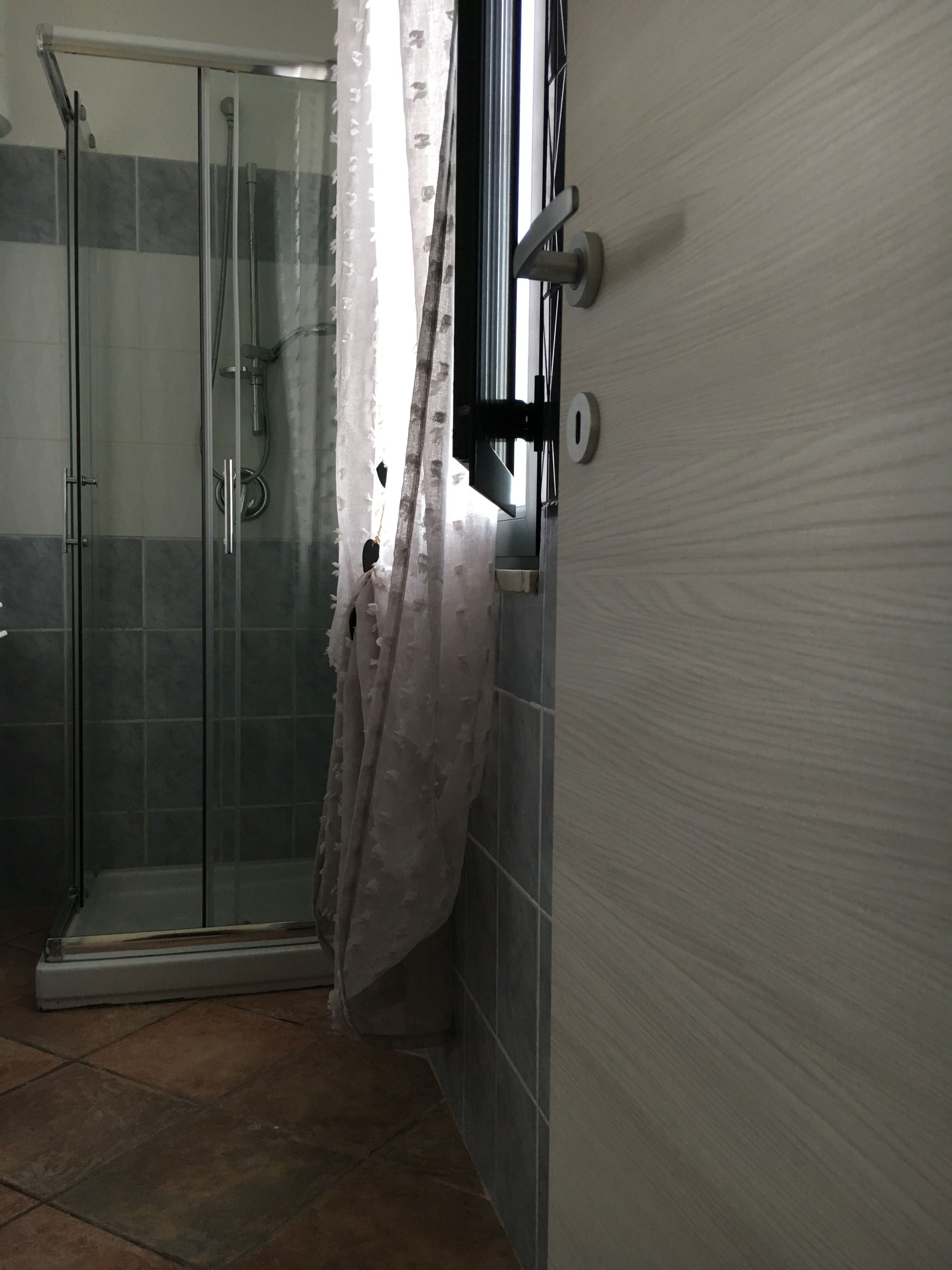 Ein Badezimmer mit Duschkabine aus Glas, Toilette und Waschbecken.
