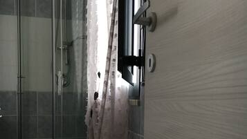 Ein Badezimmer mit Duschkabine aus Glas, Toilette und Waschbecken.