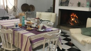 A dining area with a checkered floor, a fireplace, and a table set with breakfast items. - BeB il Pomo D'Oro (Assemini)