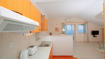 Apartamento, 1 quarto, sacada, vista para o mar | Cozinha americana privada | Geladeira, fogão, cooktop, cafeteira/chaleira