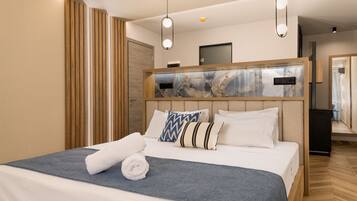 Una habitación de hotel moderna con una cama grande, un cabecero de madera y una pared de acento de mármol.