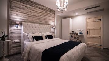 Una camera da letto con una testiera trapuntata, un lampadario, un comodino con una lampada e un armadio in legno.