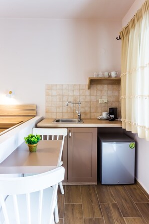 A compact kitchenette with a sink, a coffee maker, and a refrigerator.