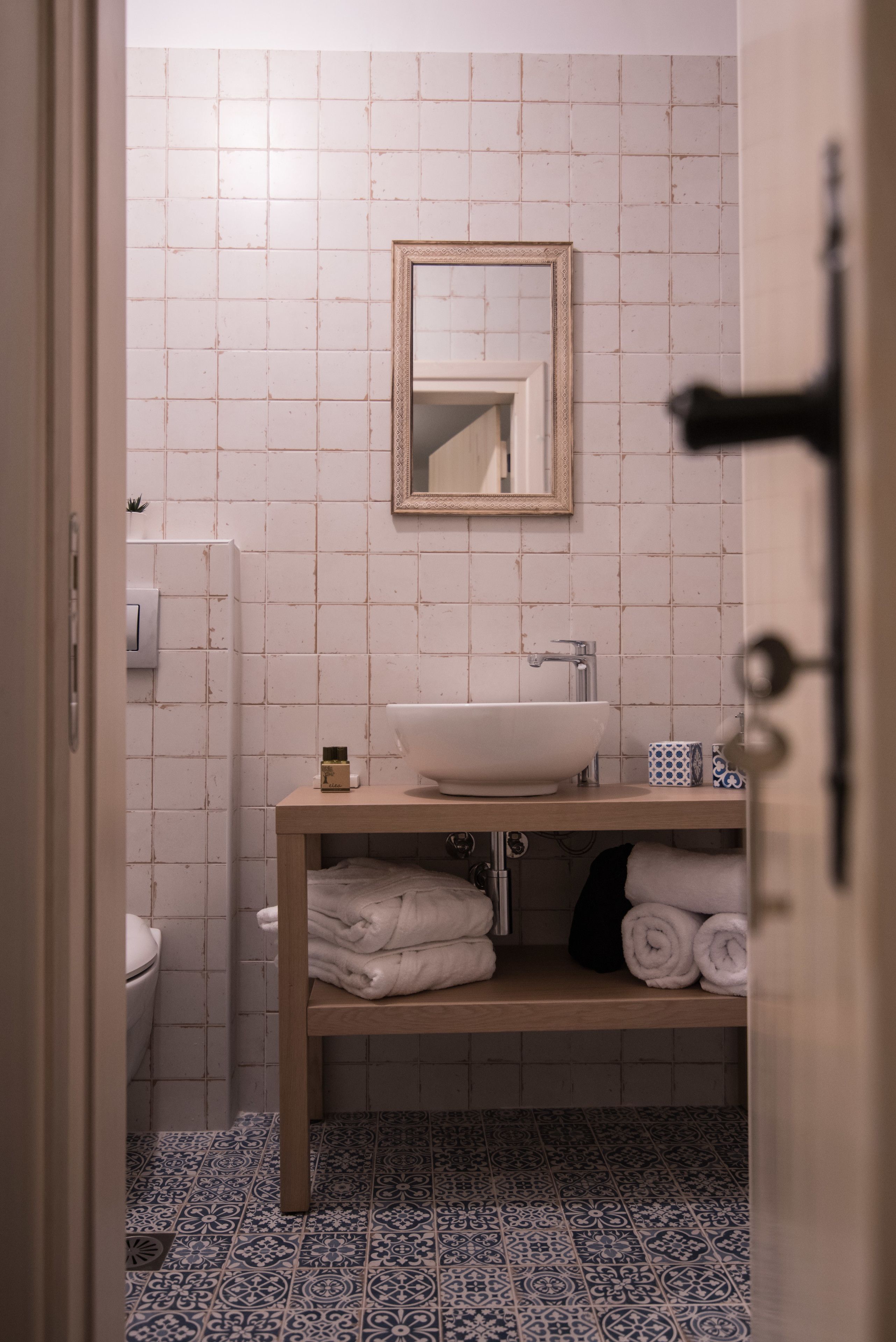 A bathroom with a white sink, a mirror, and a towel rack.