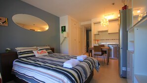 A hotel room with a bed, a desk, and a kitchenette. - Apartamento CasaTuris Bonalba Golf (Mutxamel)