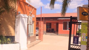 Un bâtiment avec un toit rouge, une porte d’entrée blanche et une enseigne indiquant « MTN ».
