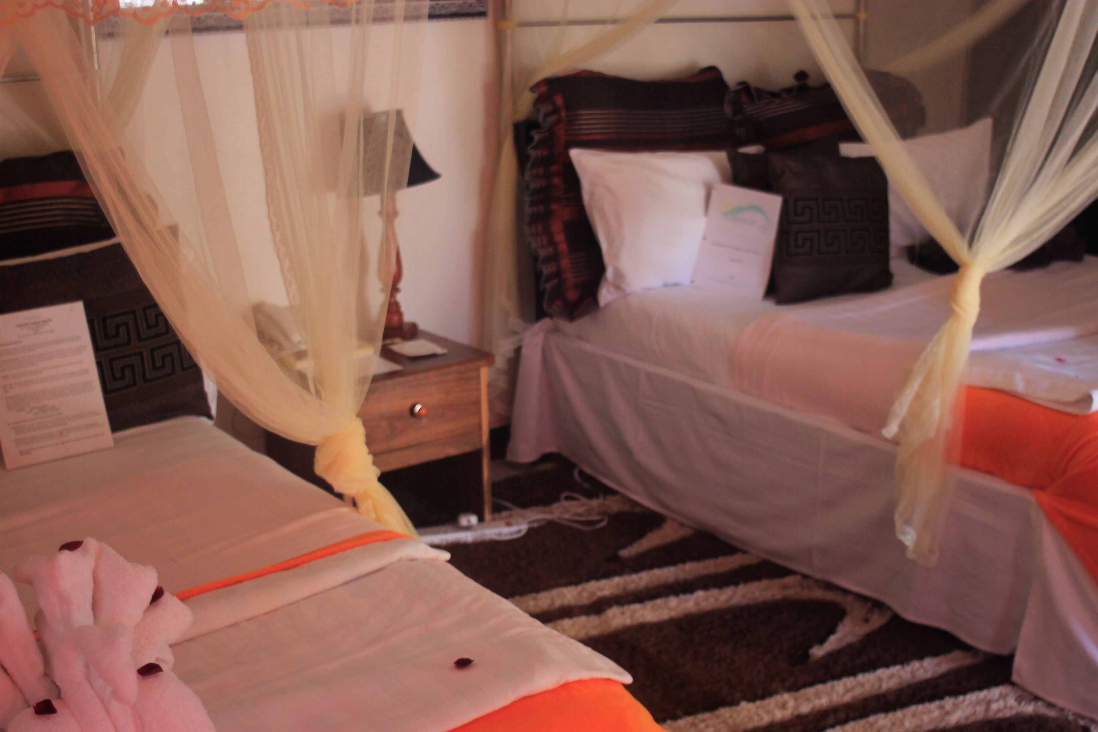 Una habitación de hotel con cama, mesita de noche, lámpara y maleta.