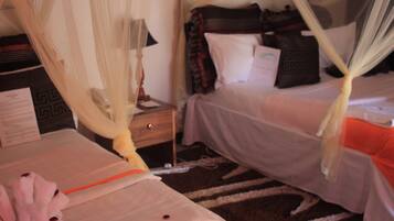 Una habitación de hotel con cama, mesita de noche, lámpara y maleta.